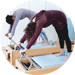 Women working out on the Reformer during a Pilates mixed equipment class